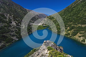 Panorama landscape with blue lake in mountains in summer. Koksai Ainakol Lake in Tien Shan Mountains in Asia in