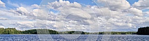 Panorama landscape with dramatic cumulus clouds in the bright summer day scene in Finland