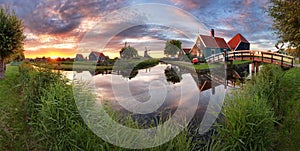 Panorama landscape windmills on water canal in village. Colorful