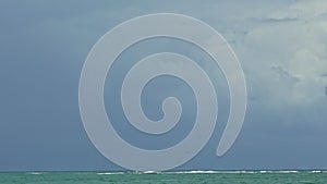 Panorama on large gray clouds on dark stormy sky above endless blue ocean