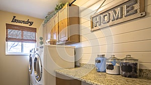 Panorama Laundry room of a home with washing machine against the wall and small window