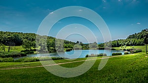 Panorama of Ljeskove vode lake. Green forest and blue sky in the background.