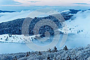Panorama of the low mountain landscape Rhoen in Germany at dusk, frosty snowy mystic winter nature photo