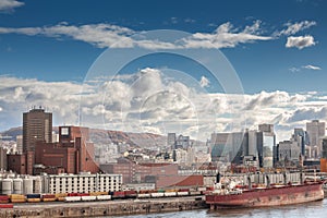 Panorama of Montreal with a cargo ship in the industrial port of Montreal, Quebec, with the skyline and center business district