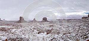 Panorama of Monument Valley covered in freshly fallen snow on a cloudy day