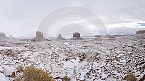 Panorama of Monument Valley covered in freshly fallen snow on a cloudy day