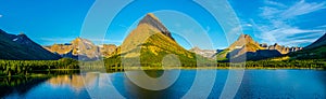 0000292_Panorama of a morning sunrise over Swiftcurrent Lake with  Mount Gould, Grinnell Point and  Mount Wilbur in the photo