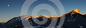 Panorama of mountain chain with lighted summits photo