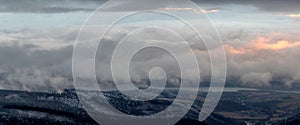 Panorama of the mountain landscape in winter over which heavy snow clouds are flowing