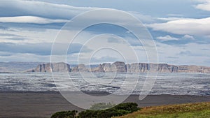 Panorama with mountain range, glacier tongue of Vatnajokull glacier and green vegetation, South Iceland