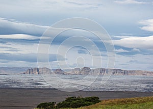 Panorama with mountain range, glacier tongue of Vatnajokull glacier and green vegetation, South Iceland