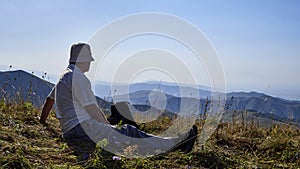 Panorama of a mountain valley in the summer. Adult man looks into the distance. The amazing nature of the mountains, sunlight at s