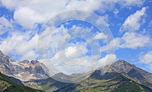 Panorama with mountains, meadows, sky and clouds