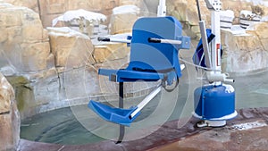 Panorama Movable blue chair and Safety first sign near a pool of hot water