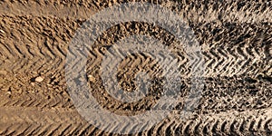 panorama of muddy road from above on surface of wet gravel road with tractor tire tracks in countryside