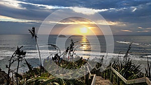 Panorama of Muriwai beach. Sunset under stormy sky