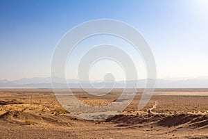 Panorama of the Namak Salt lake, seen from above, with a road visible in the foreground and a valley in the background