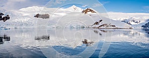 Panorama of Neko Harbor with glacier and red tents on camp site