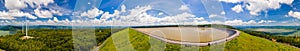 Panorama of Numerous wind turbines in the vast forest with mountains and sky as background