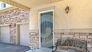 Panorama Old porch bench against stone brick wall of home with green wood front door