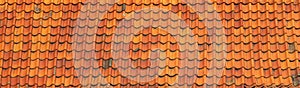 Panorama of an old rustic ceramic roof tile. Aged orange roofing tiles