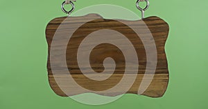 Panorama of an old wooden sign hanging from a rope. Isolated on green background