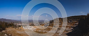 Panorama of an open mine or quarry on a sunny day at Verd, Slovenia. Visible terraces and vast surface of sand and stones, with a photo
