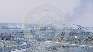 Panorama of an open quarry. Mining industry. Large quarry excavator in the background of hills of cruched stone next to