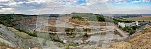 Panorama of opencast mining quarry with machinery.