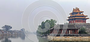 Panorama of Palace Museum at the Forbidden City and the surrounding water filled moat and heavy clouds in Beijing, China