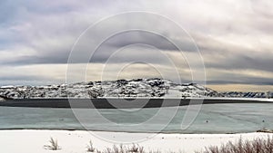 Panorama Panoramic view of a frozen lake and snowy mountain under cloudy sky in winter
