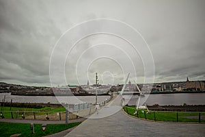 Panorama of peace bridge in Derry or Londonderry spanning across the river on a sunny spring day. Beautiful modernist bridge to