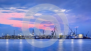 Panorama of a petrochemical production plant against a dramatic colored sky at twilight, Port of Antwerp, Belgium.