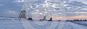 Panorama photo of a sunrise on a cold winter morning with a snowy landscape at the three windmills in Leidschendam, The Netherland