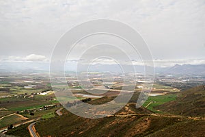 Panorama photo of wheatfields, irrigation dams and blue mountains in the background.