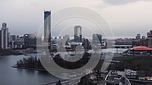 Panorama of the pond and Yekaterinburg Iset skyscraper. Stock footage. Aerial view of Dinamo building with round orange photo