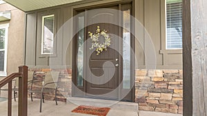 Panorama Porch and front door of a home with wood and stone brick wall sections