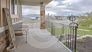 Panorama Porch overlooking yard road homes lake and mountain under cloudy blue sky