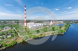 Panorama of power plant with pipes on lake in summer