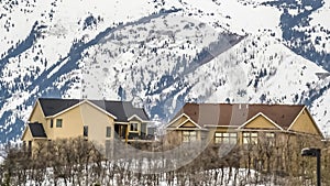 Panorama Residences with towering snow capped mountain and overcast sky in the background