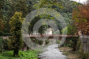 Panorama of the river Cerna in Baile Herculane, with te podul de fonta, or cast iron bridge, a rusty vintage bridge, in the middle photo