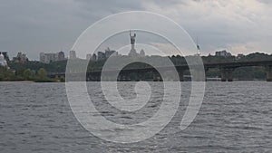 Panorama of River Dnipro with Paton Bridge. Cityscape with Kyiv\'s hills with buildings and Motherland Monument on horizon