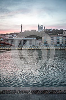 Panorama of riverbank of Saone river in Lyon, at dusk, with Colline and Basilique de Fourviere Church and hill behind. photo