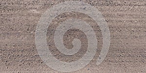 Panorama of road from above on surface of gravel road with car tire tracks
