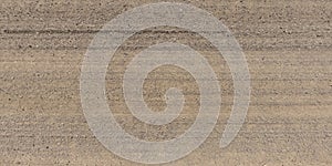 panorama of road from above on surface of gravel road with car tire tracks in countryside