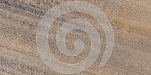 panorama of road from above on surface of gravel road with car tire tracks in countryside