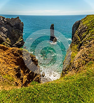 A panorama of a rock stack viewed down a secluded inlet on the Pembrokeshire coast, Wales near Castlemartin