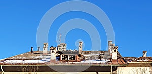 Panorama of the roof of the house with chimneys against the blue sky.