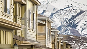 Panorama Row of townhouses in winter with snow covered mountain and cloudy sky background