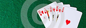 Panorama. Royal flush of hearts on green background. Winning hands of poker playing cards